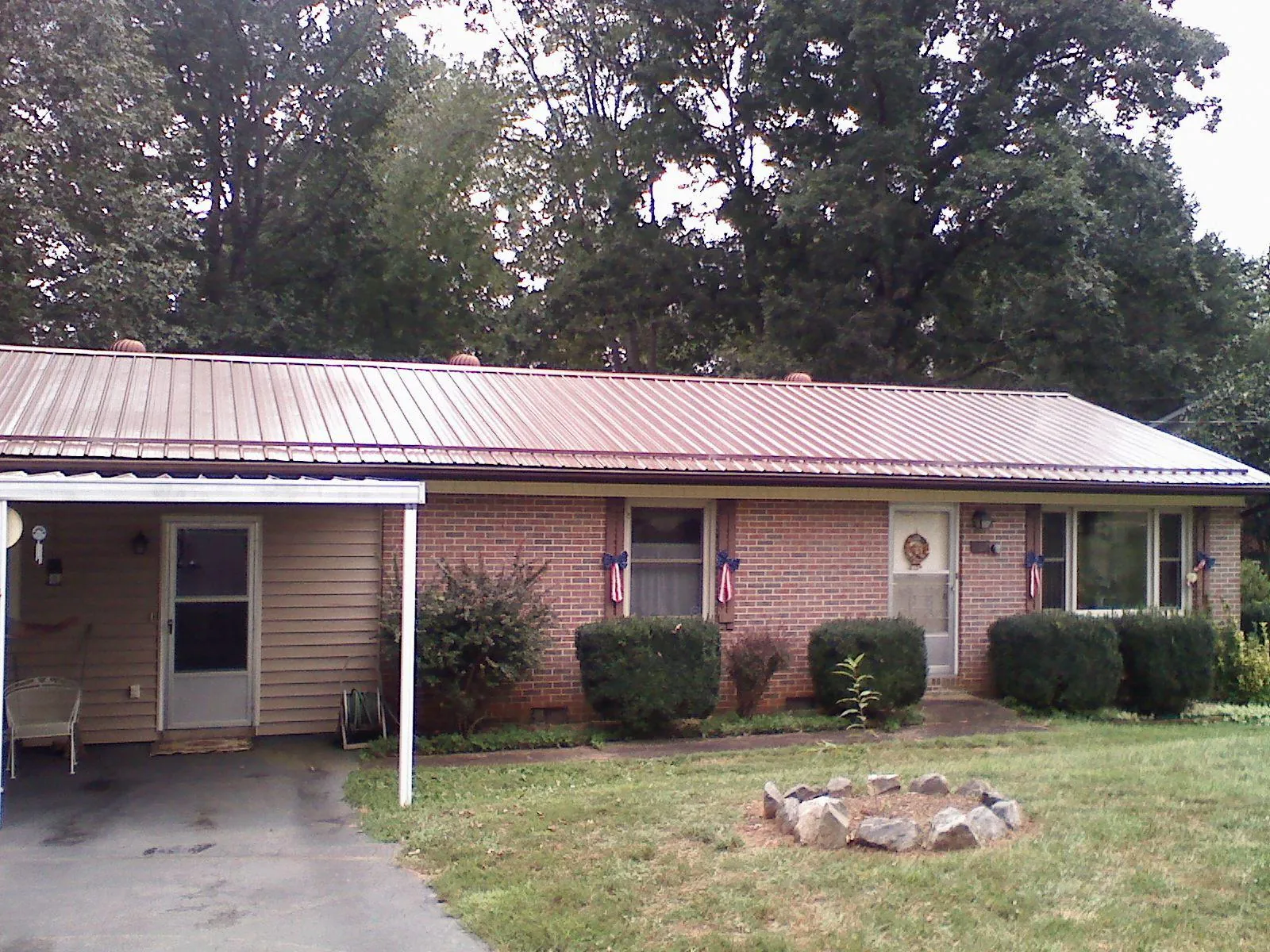 Bronze metal roof and carport on a brick ranch home — Roof Repair work by our crew in Wacissa